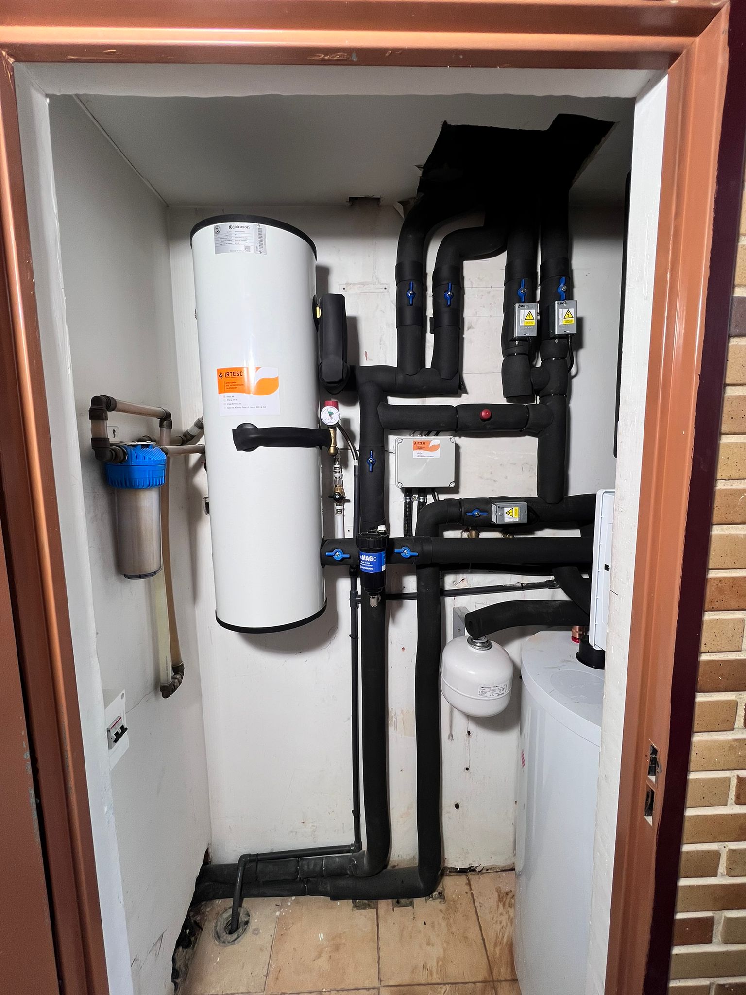 Instalación de aerotermia con acumulador y tuberías aisladas en vivienda